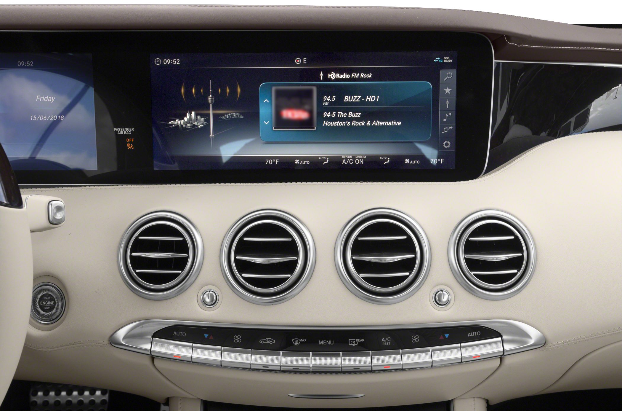 Digital infotainment screen and four circular air vents on car dashboard