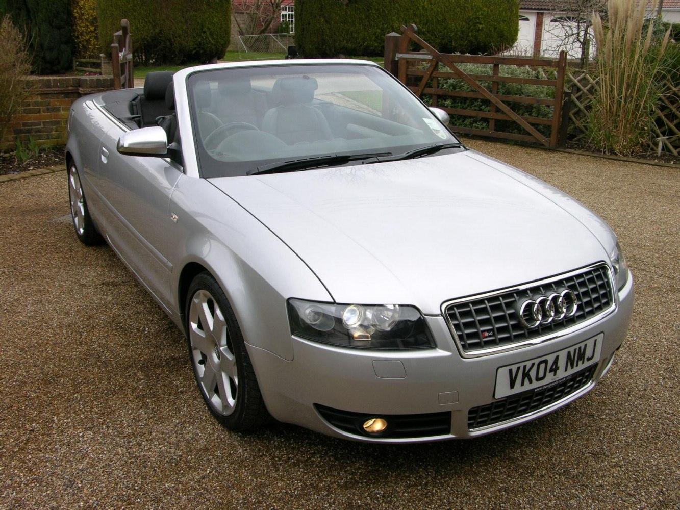 Silver convertible with front grille, headlights, and alloy wheels