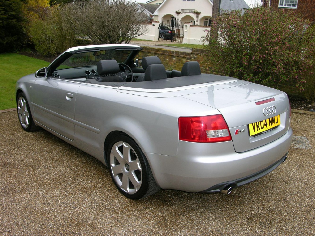 Silver convertible with rear view, alloy wheels, and open roof.