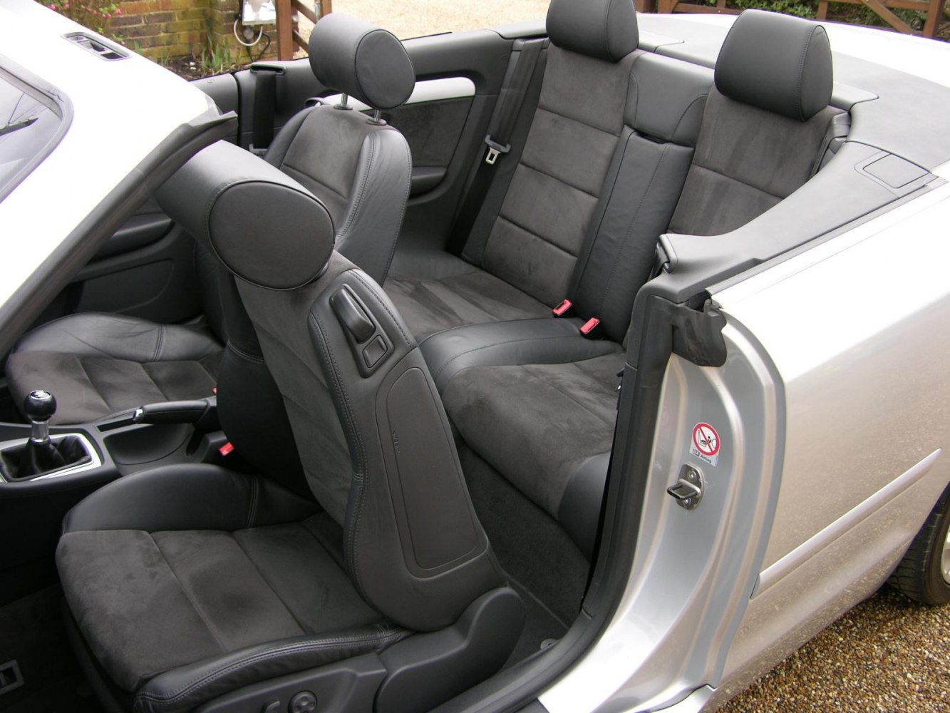 Convertible car interior with leather and suede seats, spacious rear seating
