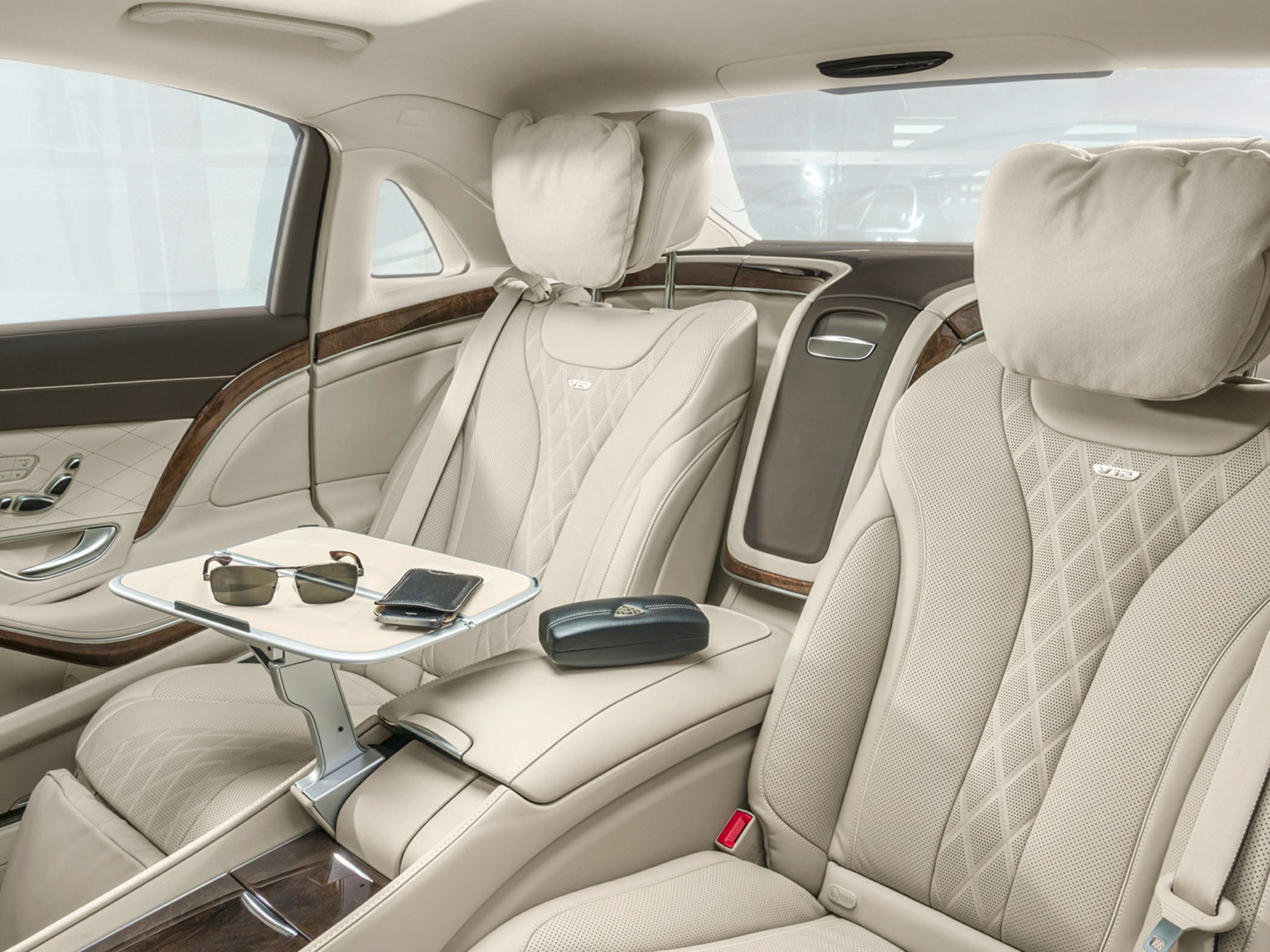 Plush leather rear seats with integrated headrest cushions and fold-out table