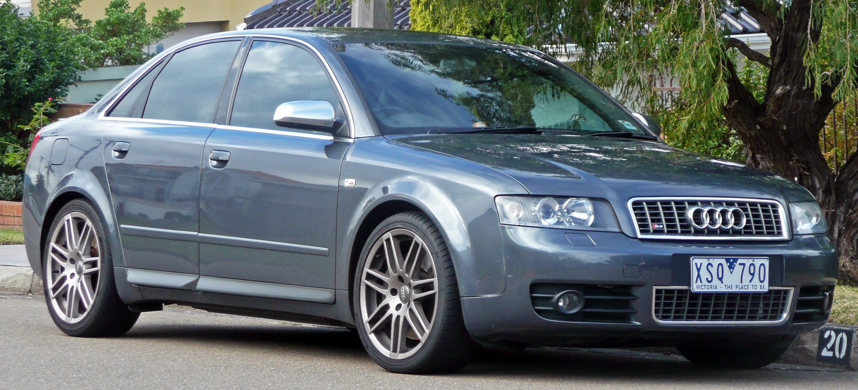 Front side view of a sedan with grille and alloy wheels