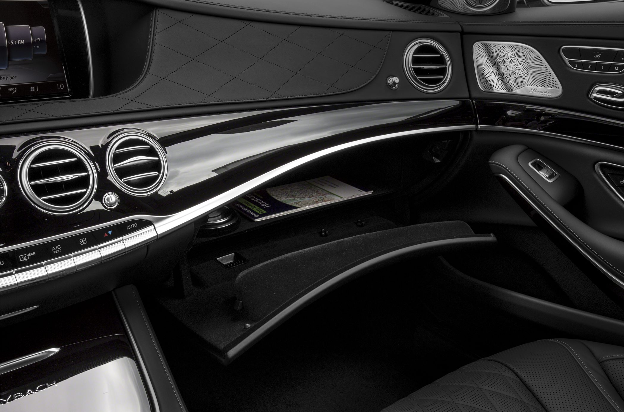 Luxury dashboard and open glovebox with air vents and speaker grille
