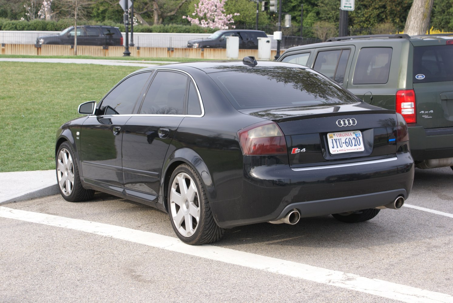 Rear view of a black sedan with dual exhaust and alloy wheels