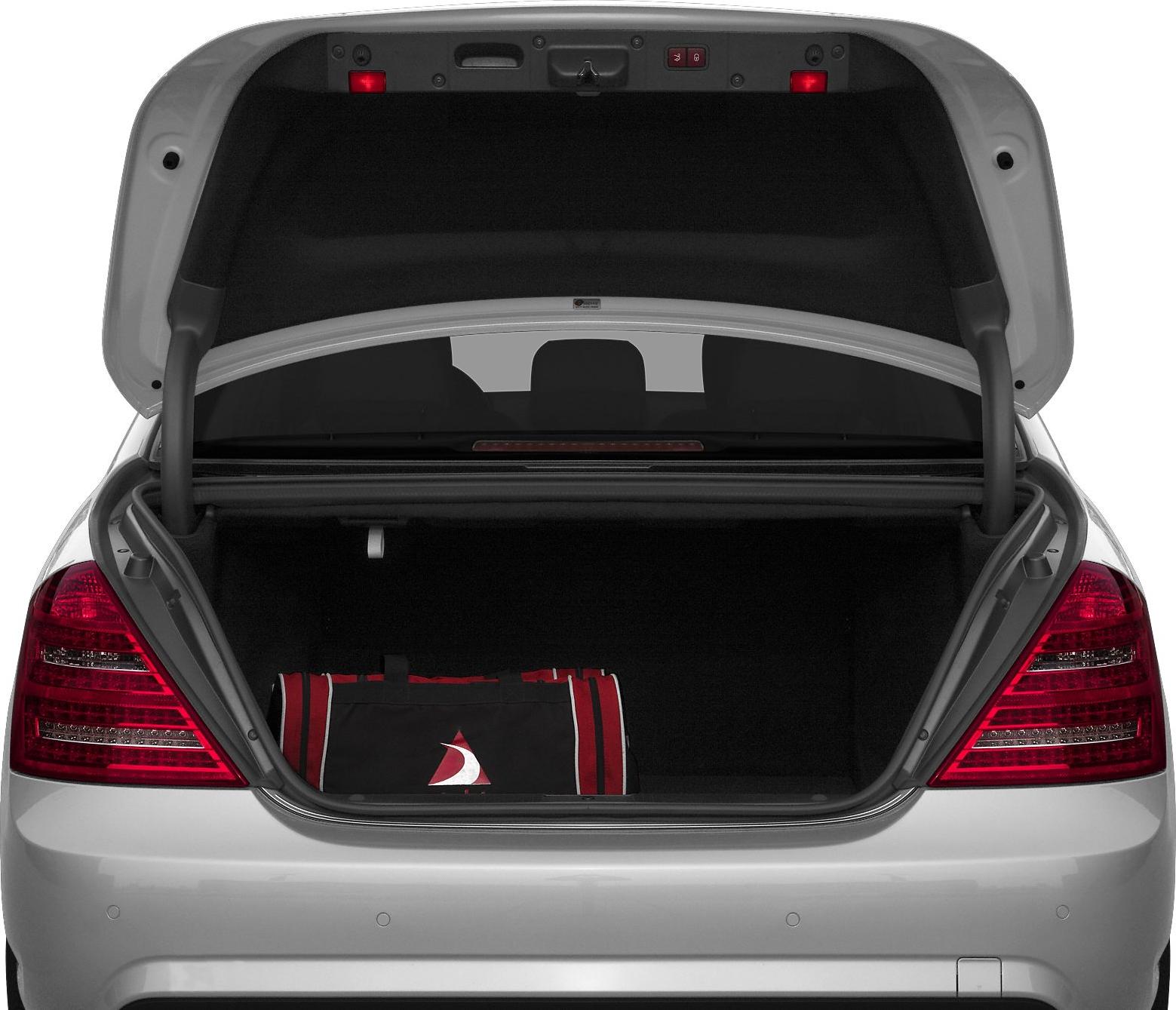 Open trunk space with luggage inside, illuminated by trunk lights.
