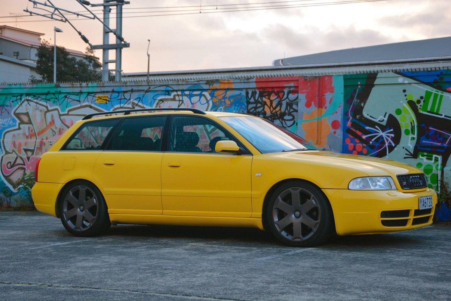 Bright yellow sport wagon with black alloy wheels and lowered stance