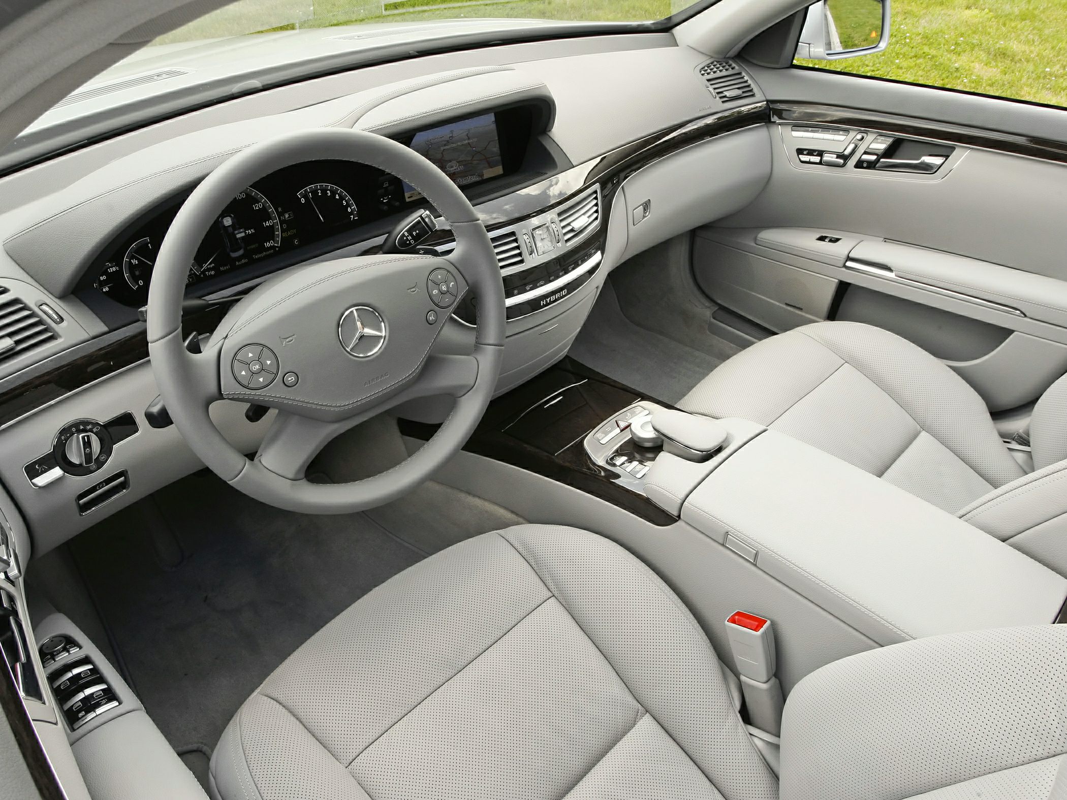 Luxurious dashboard and steering wheel with wood trim and advanced controls.