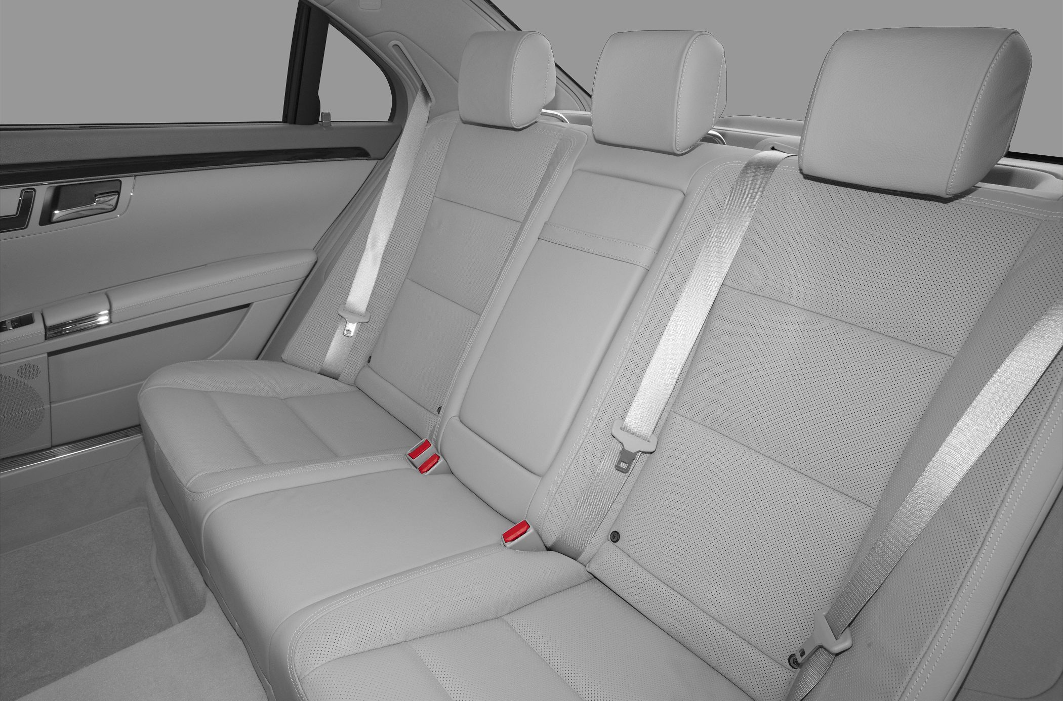 Leather rear seats with headrests and seat belts in a spacious sedan interior.
