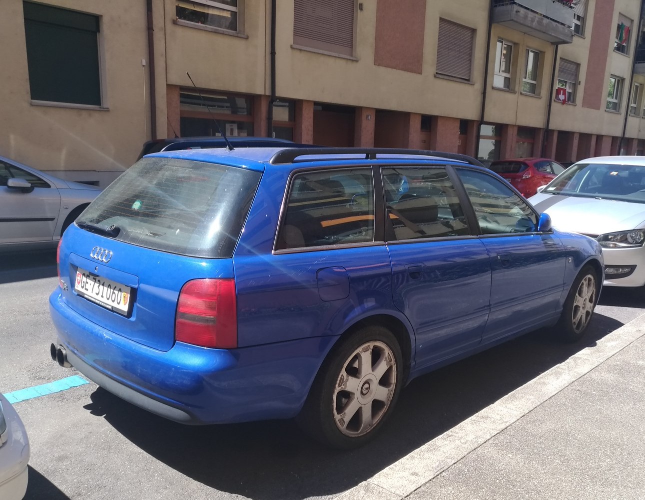 Blue station wagon rear with roof rails and dual exhaust