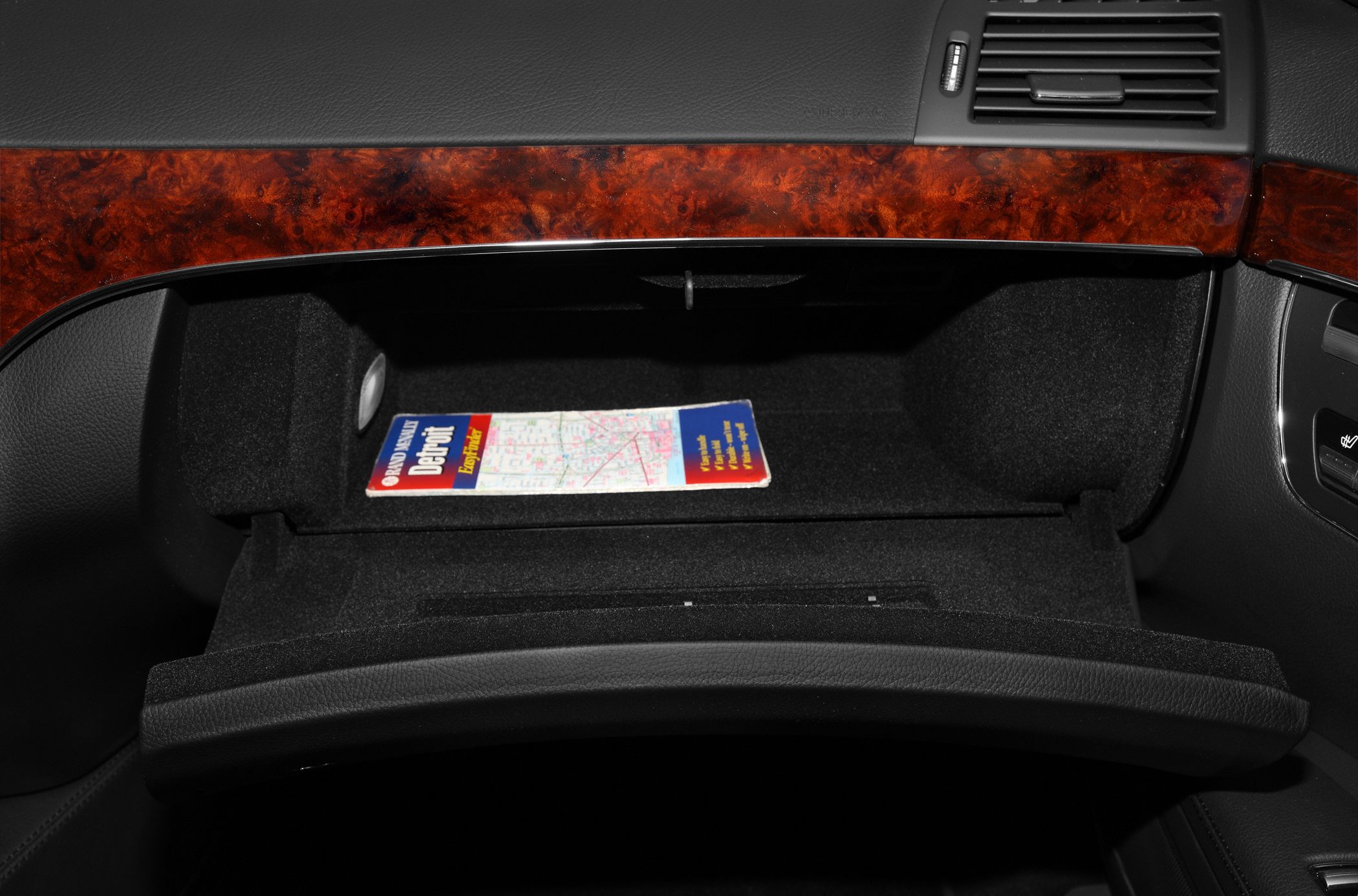 Luxury wood dashboard with open glove compartment and map inside