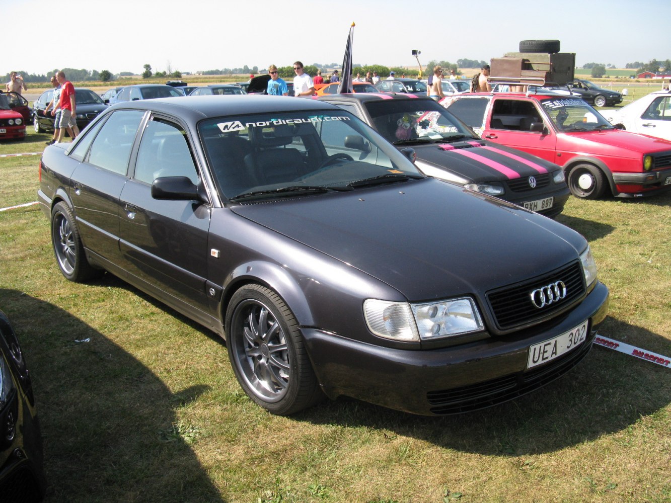 Black sedan with rectangular headlights and multi-spoke alloy wheels