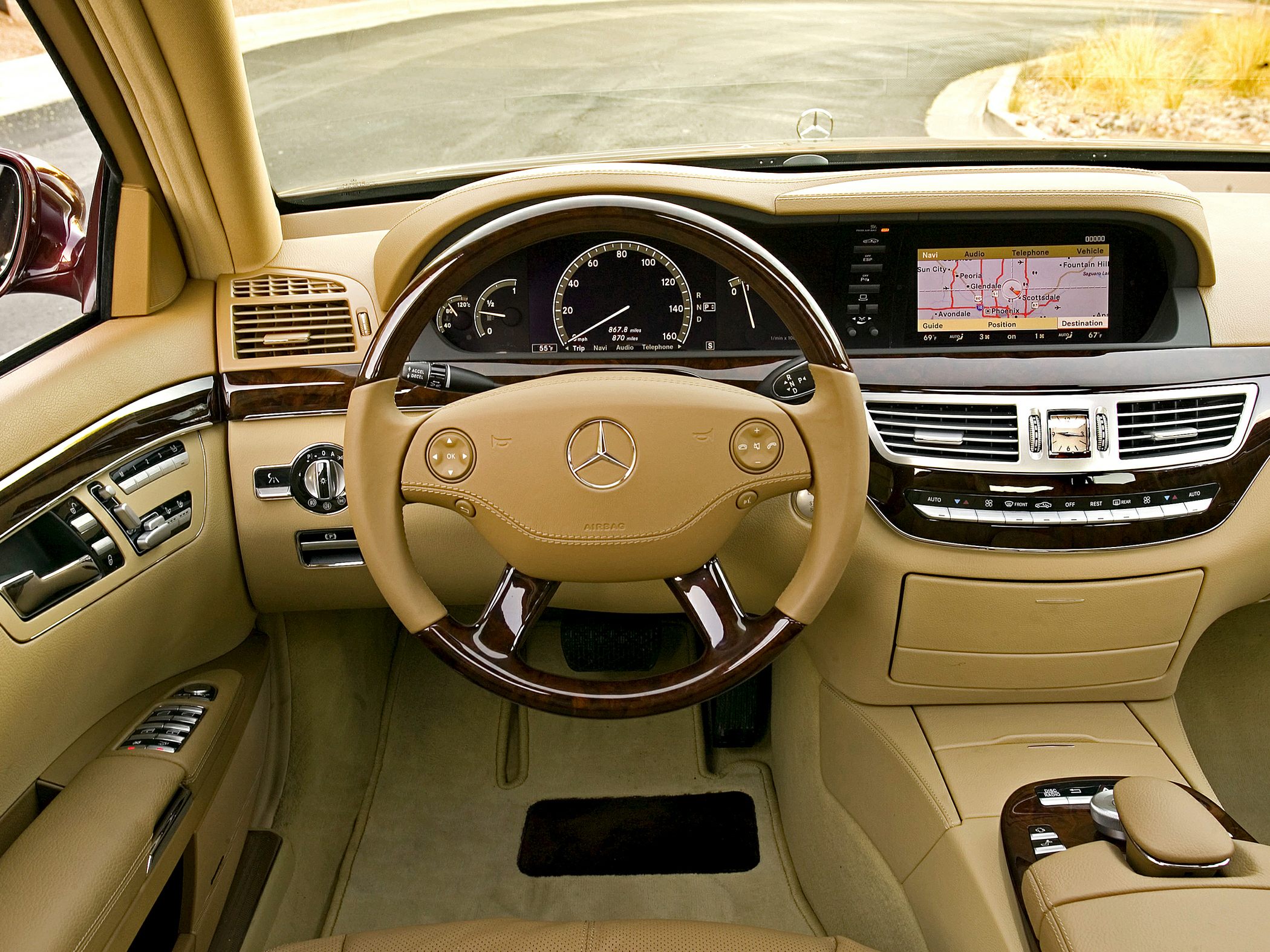 Luxury dashboard and steering wheel with navigation screen and wood trim