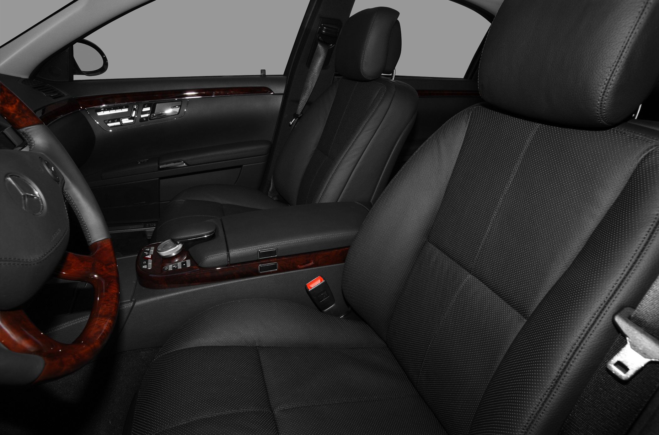 Black perforated leather front seats with wood trim and armrest console