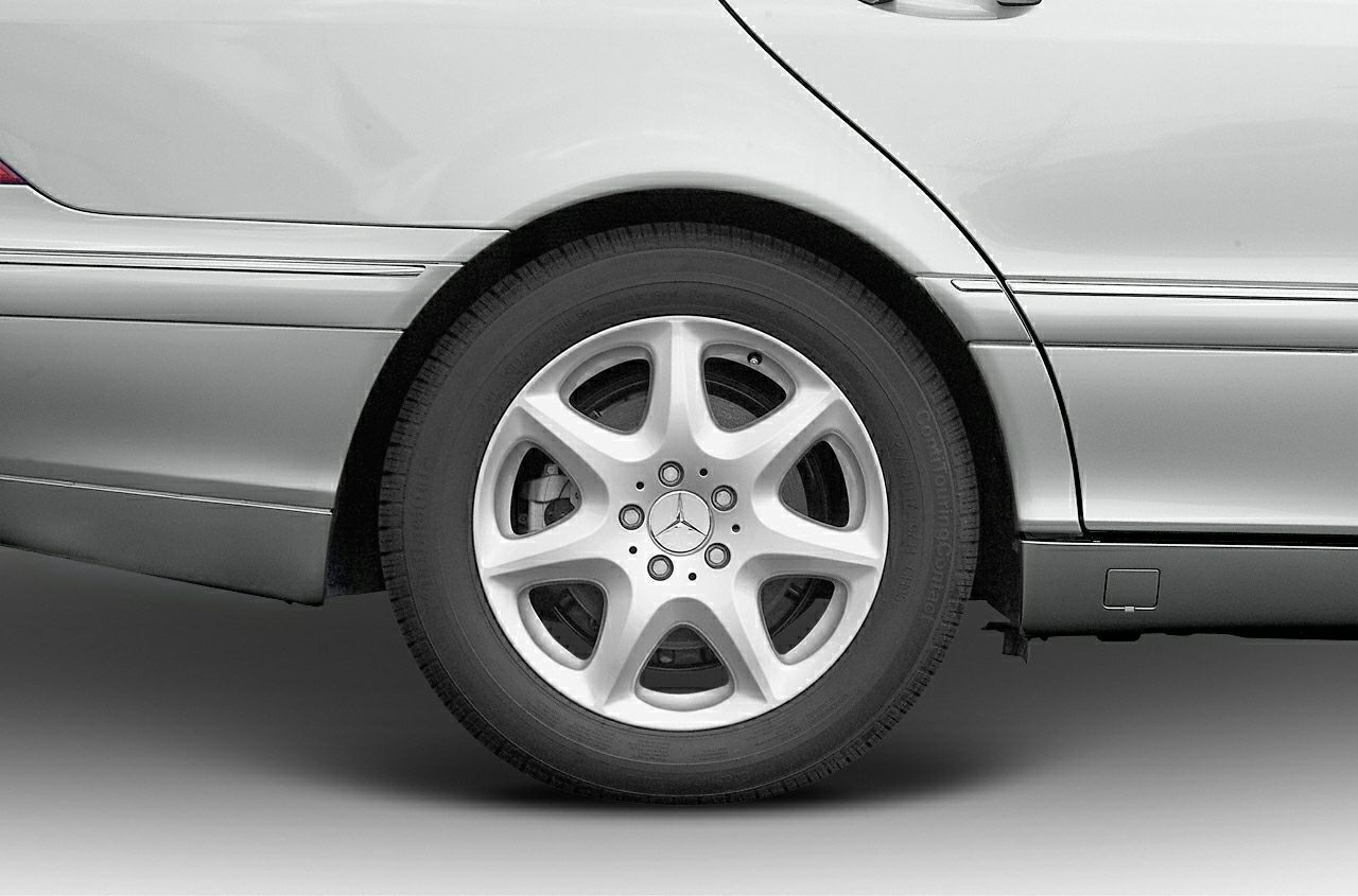 Rear alloy wheel and lower body panel with trim on a silver luxury sedan.