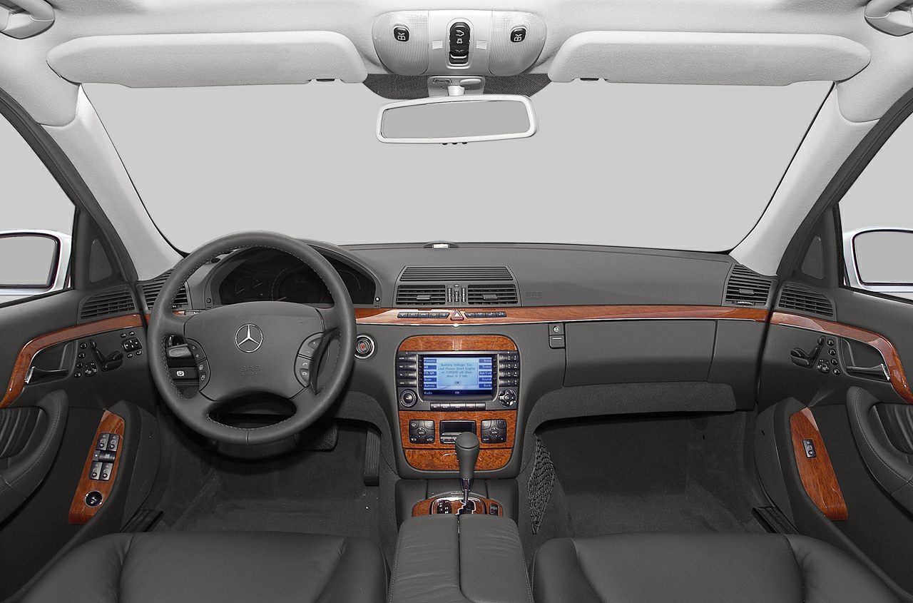 Luxury car interior with wood trim dashboard and multifunction steering wheel