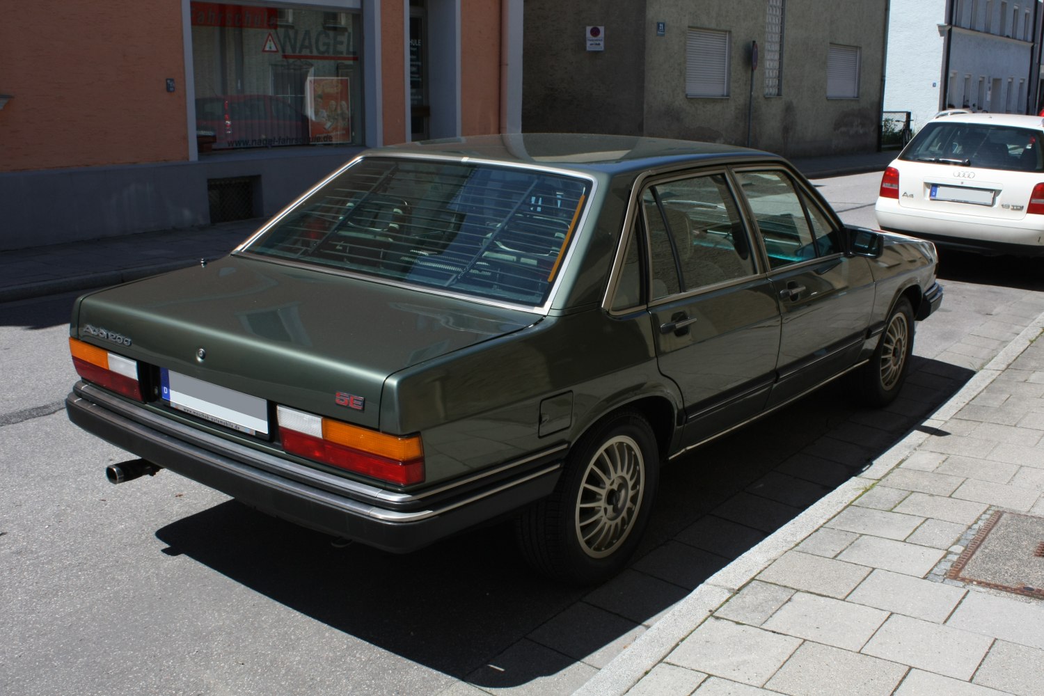 Rear and side view of vintage 1980s sedan with alloy wheels and characteristic tail lights.