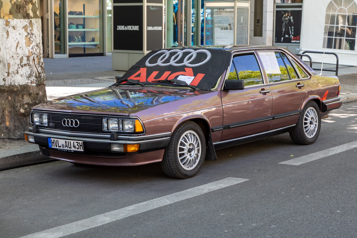 Vintage sedan with quad headlights, distinct grille, alloy wheels