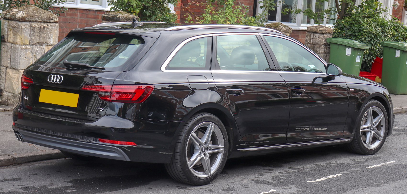 Rear side view of a black station wagon with distinctive taillights and alloy wheels