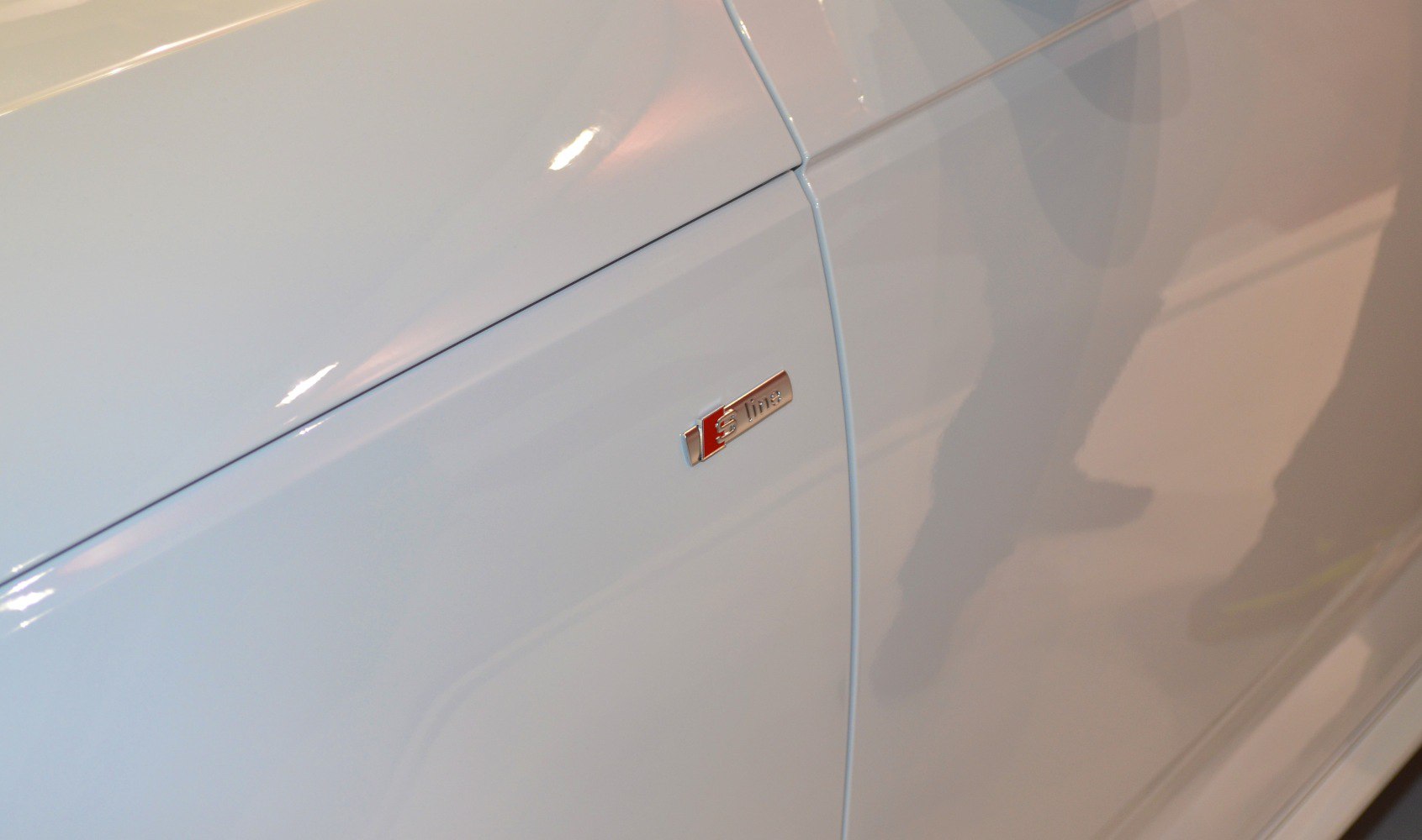 Close-up of S line badge on white car side panel
