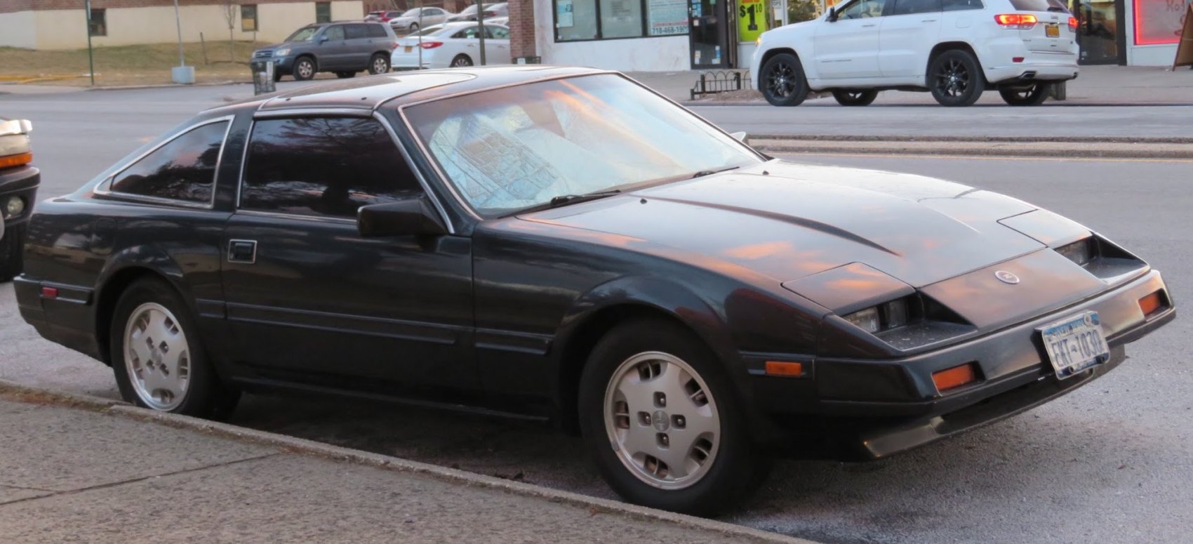 Side profile of a classic sports coupe with pop-up headlights and angular design.
