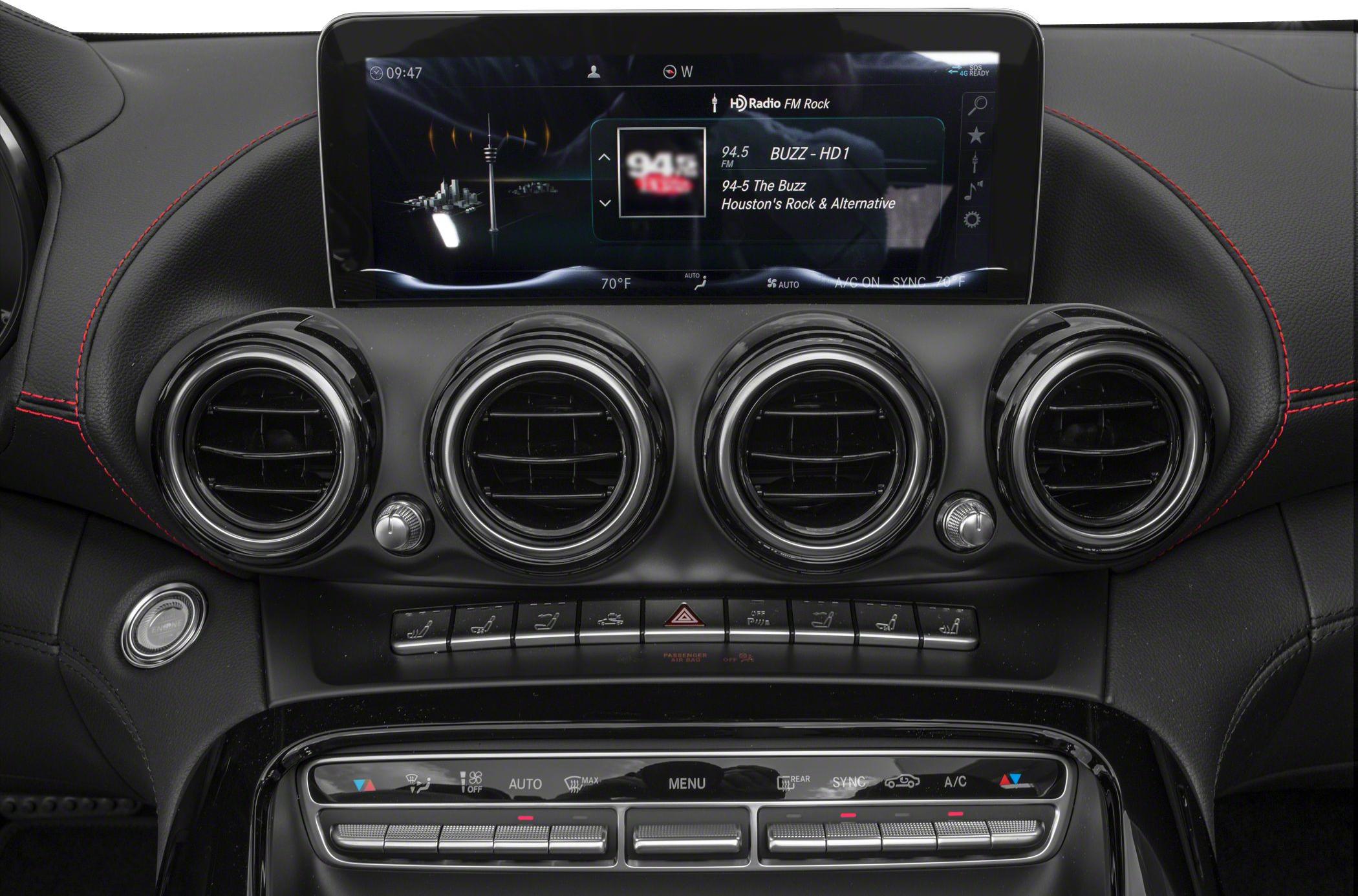 Dashboard with digital infotainment screen, four round air vents, and climate control buttons