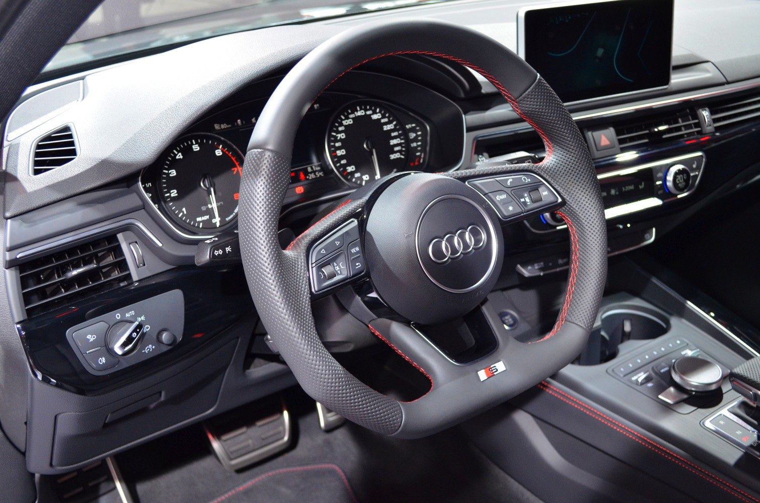 Sporty steering wheel with red stitching and digital dashboard cluster