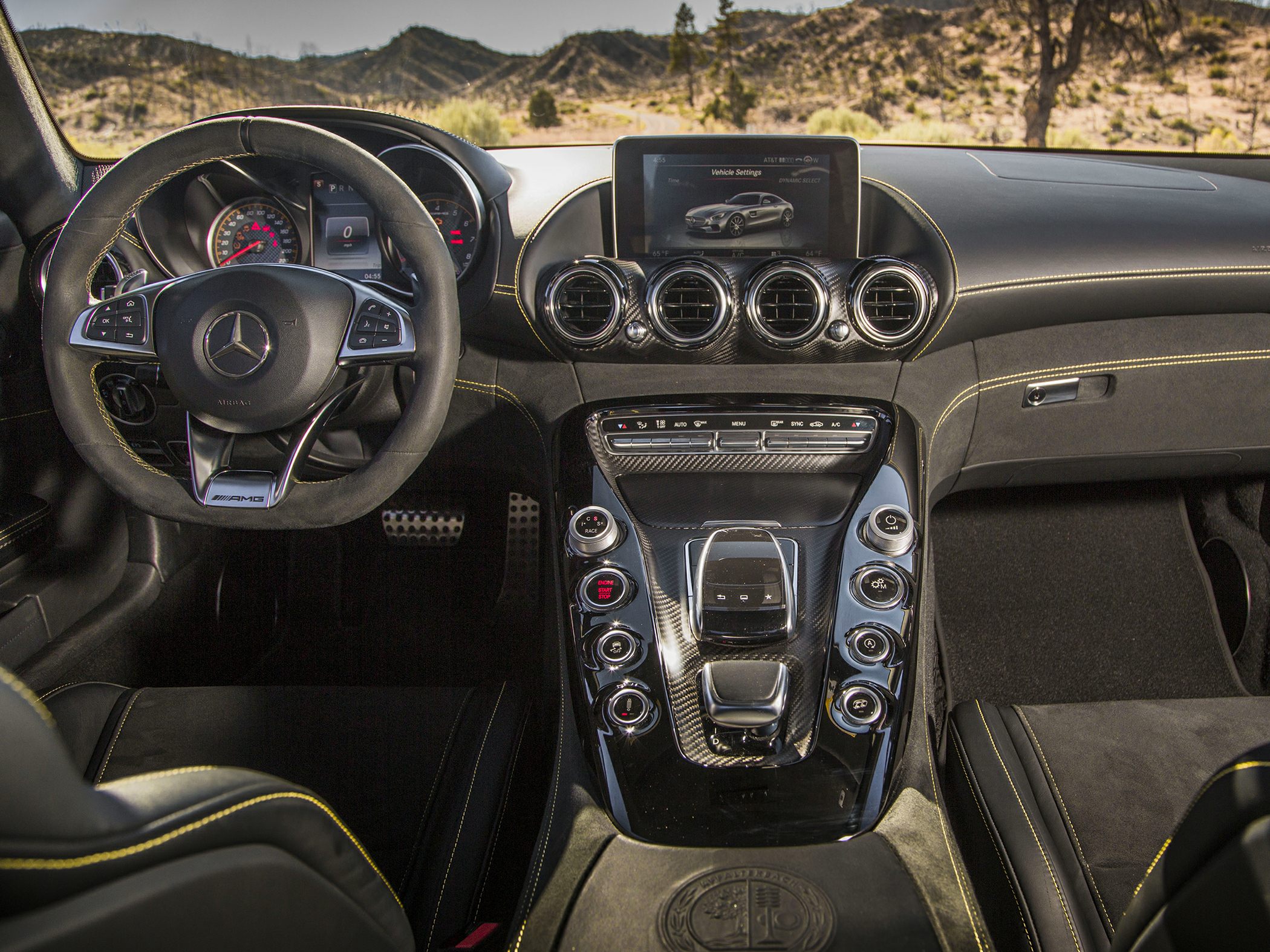 Luxury sporty car interior with multifunction steering wheel and central console.