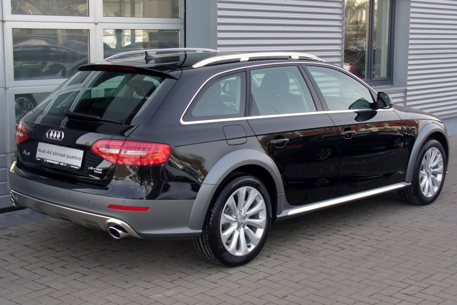 Black station wagon with rear-side view, alloy wheels, roof rails