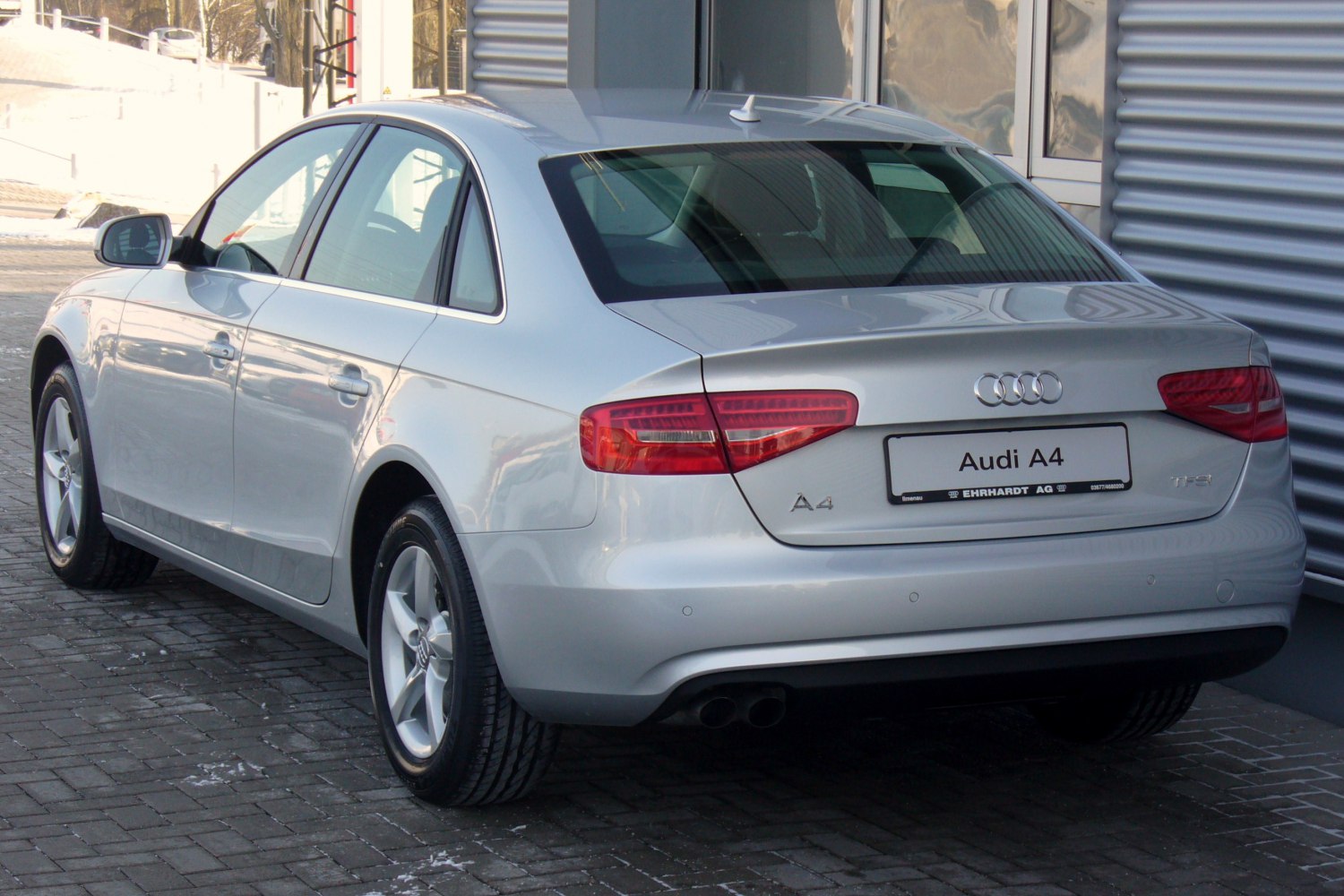 Silver sedan rear view with tail lights and dual exhaust pipes