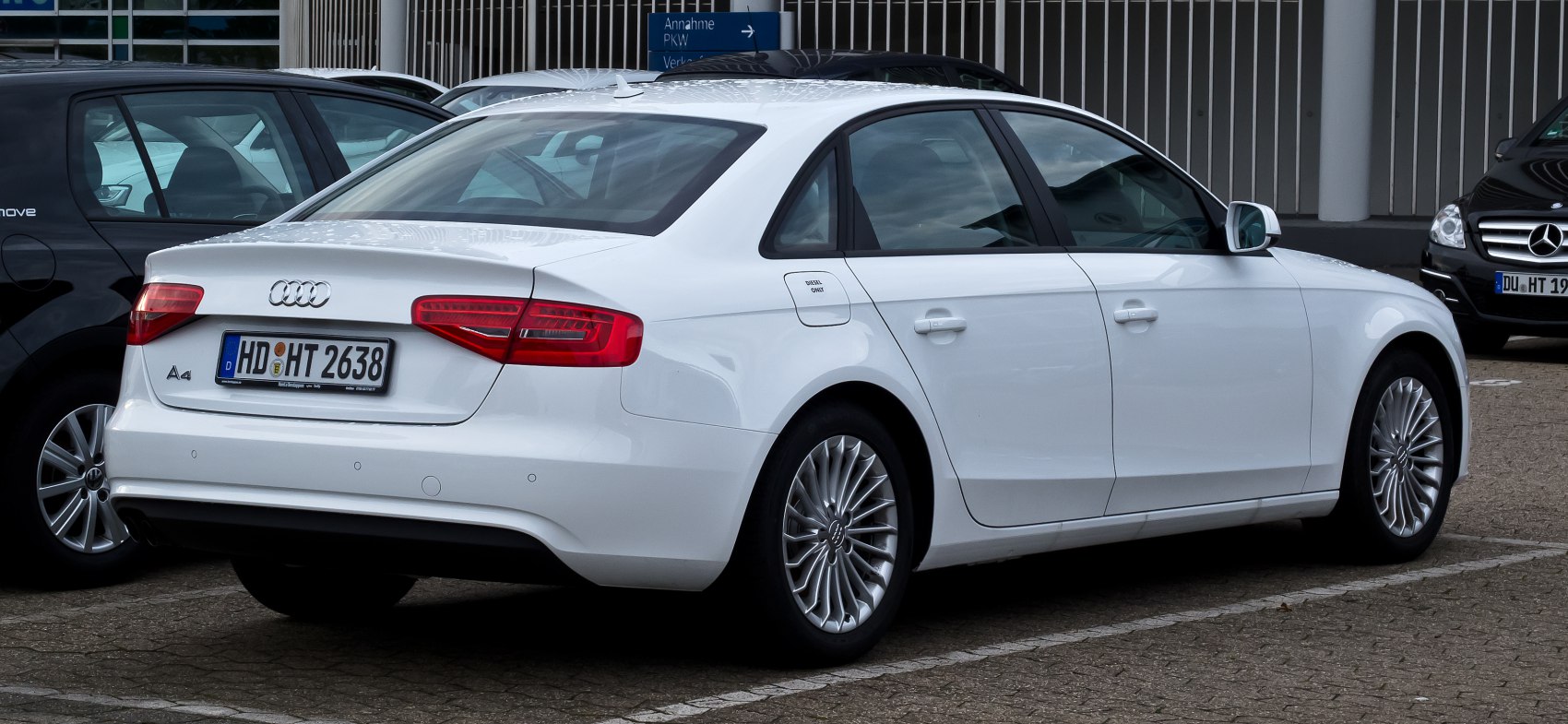 White sedan rear side view with distinct tail lights and alloy wheels
