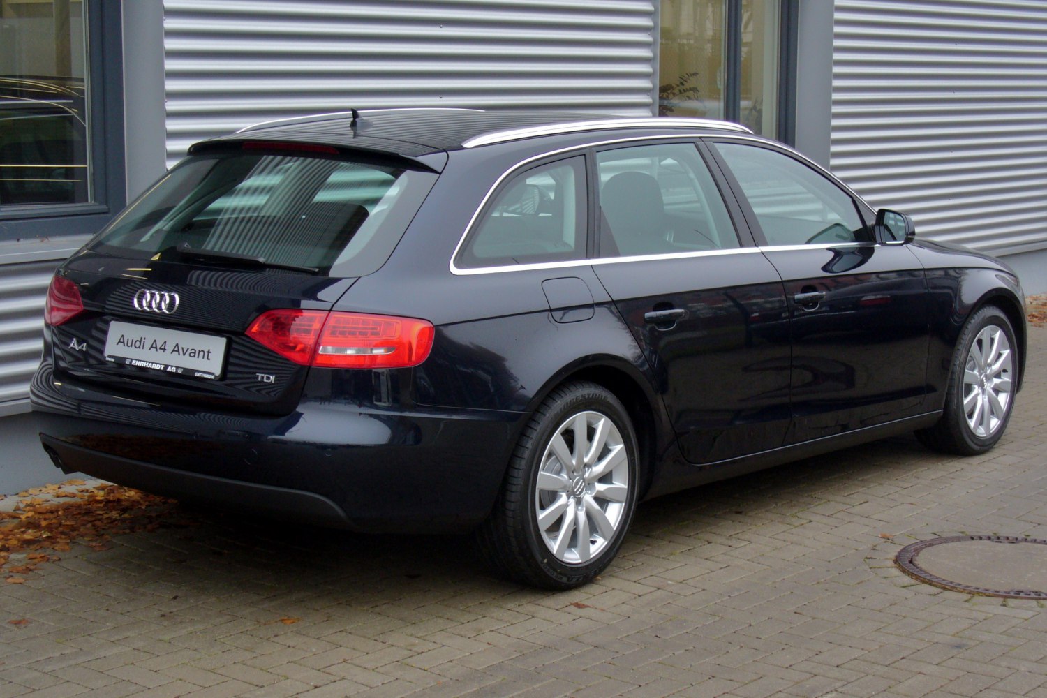 Rear side view of an estate car with prominent taillights and alloy wheels
