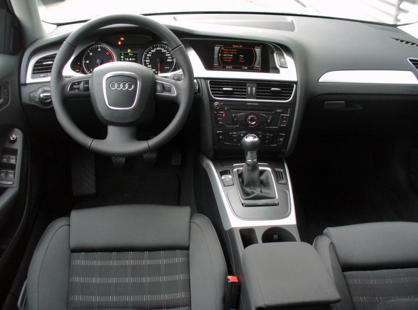 Dashboard with steering wheel, instrument cluster, infotainment screen, and manual gearshift
