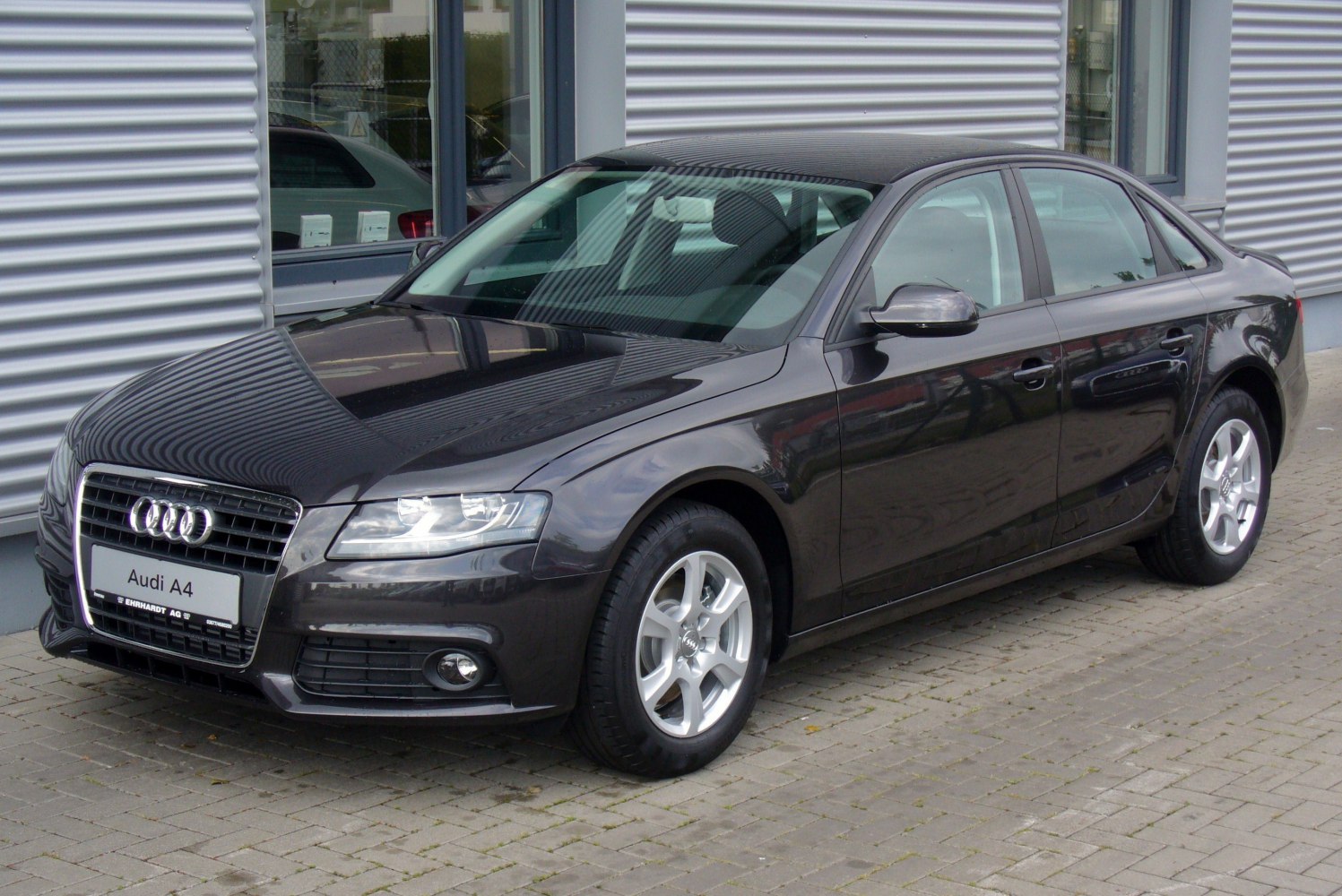 Front side view of a sedan with headlights and alloy wheels