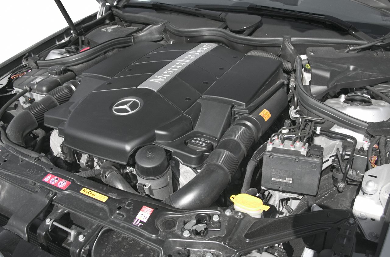 Close-up of Mercedes engine bay with branded cover and components