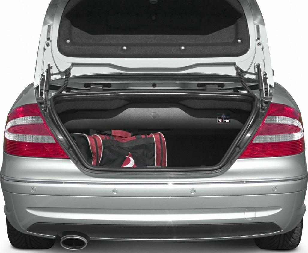 Open trunk with bag, rear view, tail lights, and exhaust pipe.