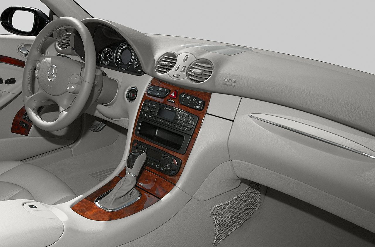 Dashboard interior with wood trim, analog gauges, and gear shift