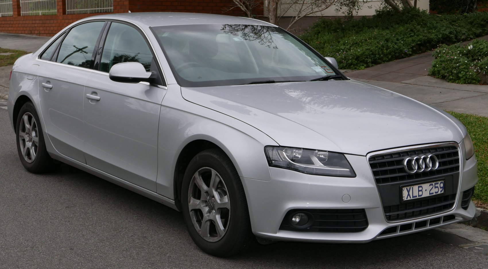 Silver sedan front-side view with distinctive headlights and grille