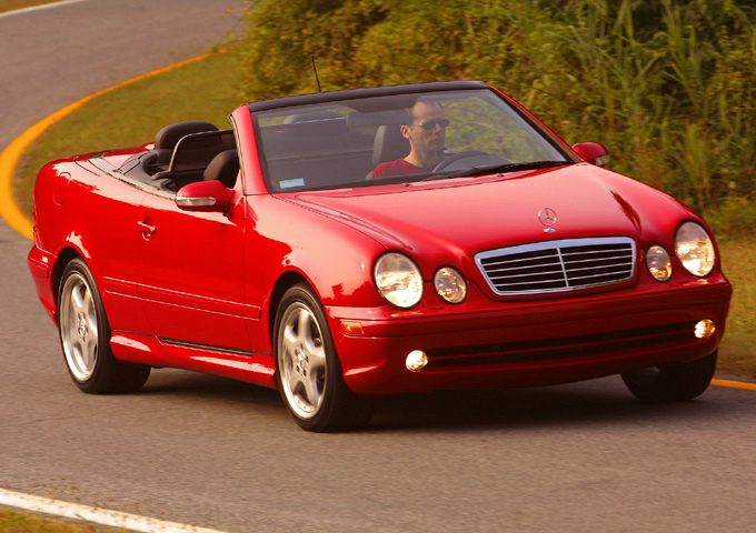 Red convertible with round headlights, chrome grille, and alloy wheels.