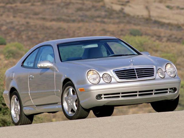 Silver coupe with dual round headlights and chrome grille.