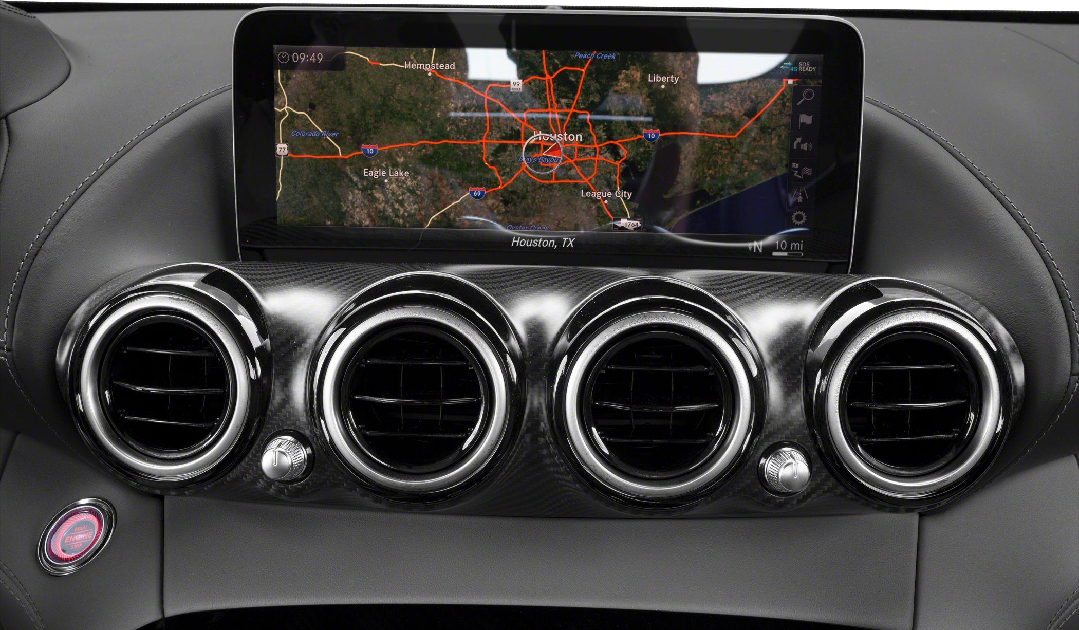 Four circular air vents and navigation screen on carbon fiber dashboard