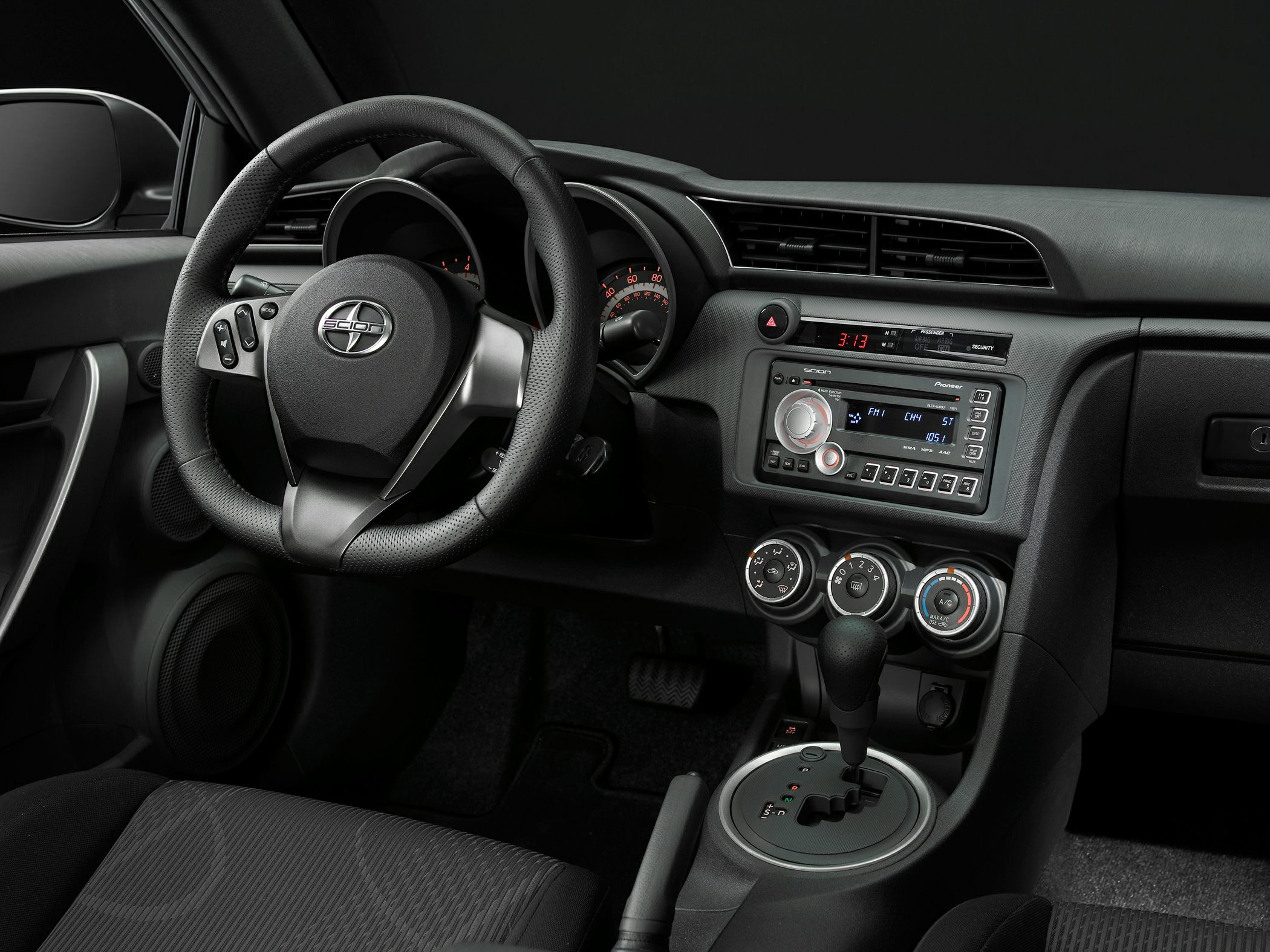 Steering wheel, dashboard, and center console with digital display and controls.