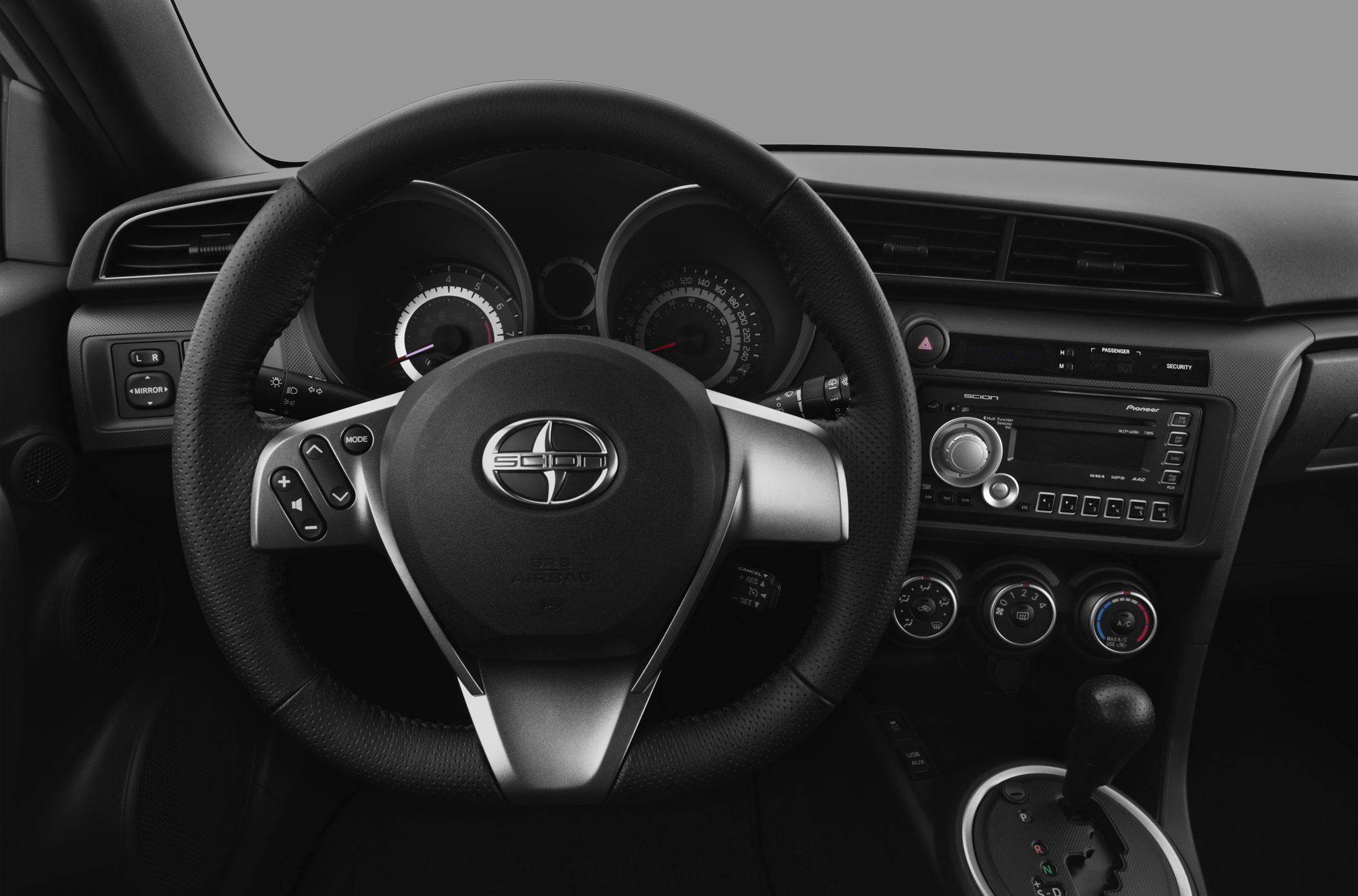 Steering wheel with controls and dashboard featuring gauges and infotainment.