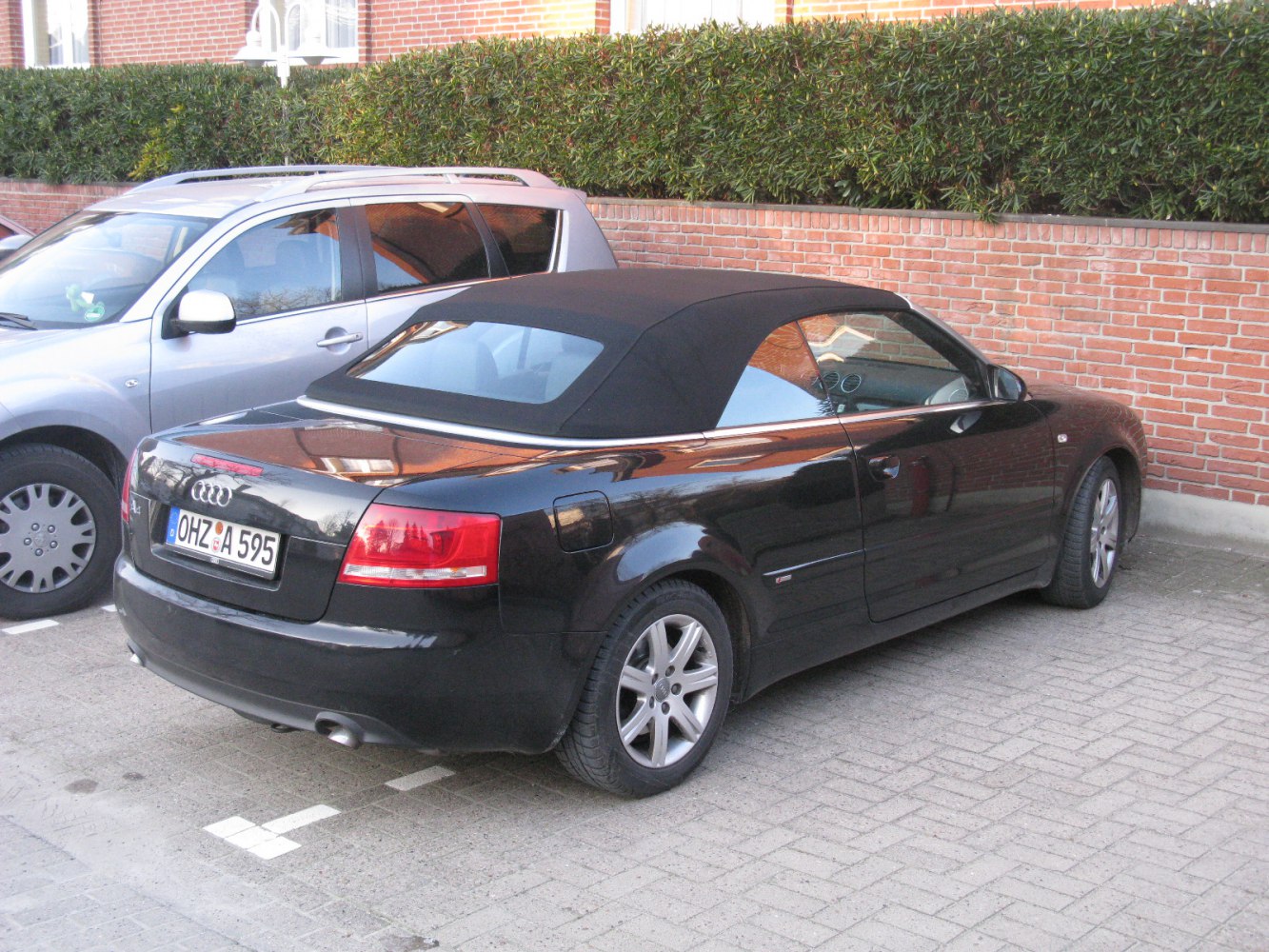 Rear view of black soft-top convertible with alloy wheels