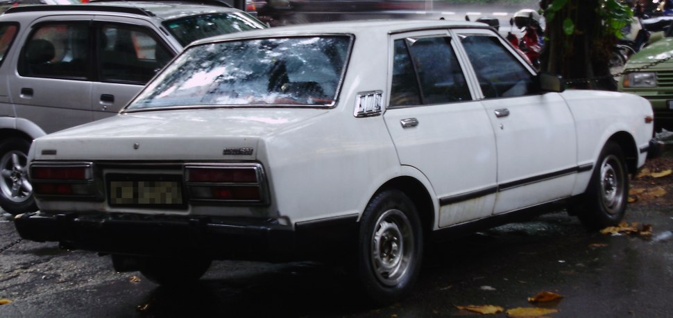 Rear view of a vintage 1970s compact four-door sedan with distinct taillights.