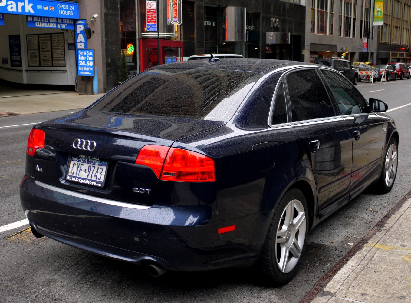 Rear-side view of dark blue sedan with 2.0T badge and alloy wheels