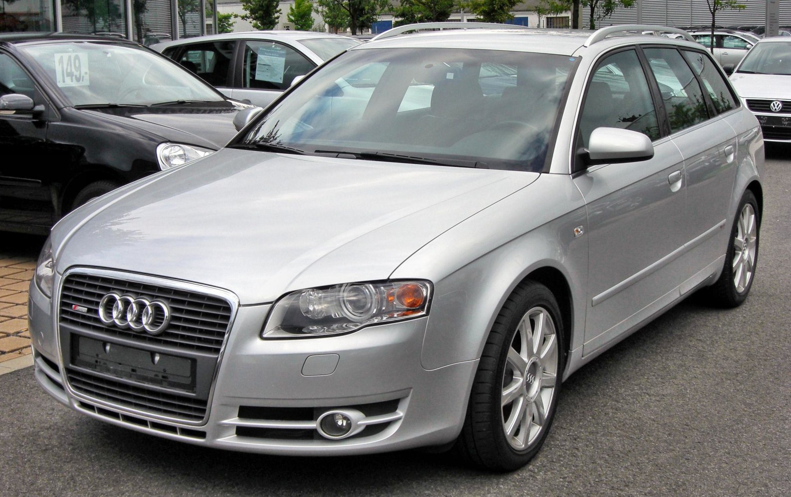 Silver station wagon with front grille, headlights, alloy wheels, and roof rails.