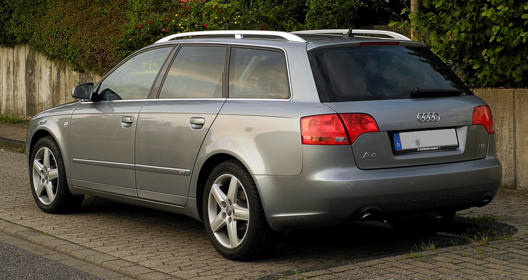 Rear side of a station wagon with alloy wheels and roof rails