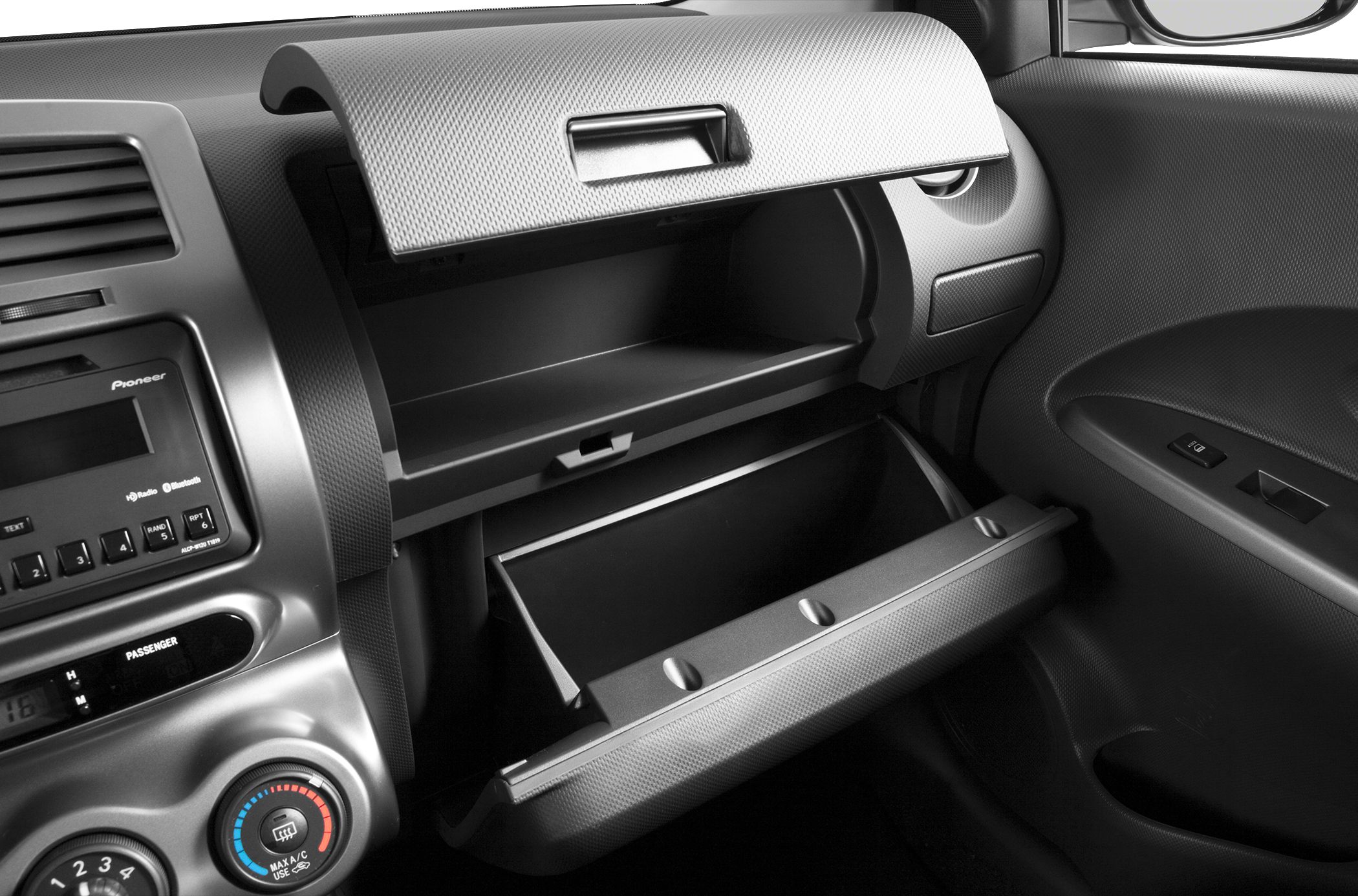 Dashboard interior with two open glove compartments and audio controls