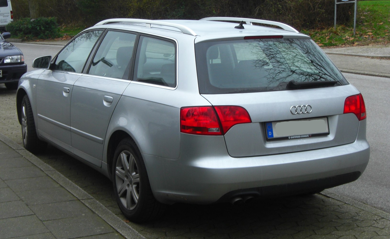 Silver estate car rear-side view with roof rails and red taillights
