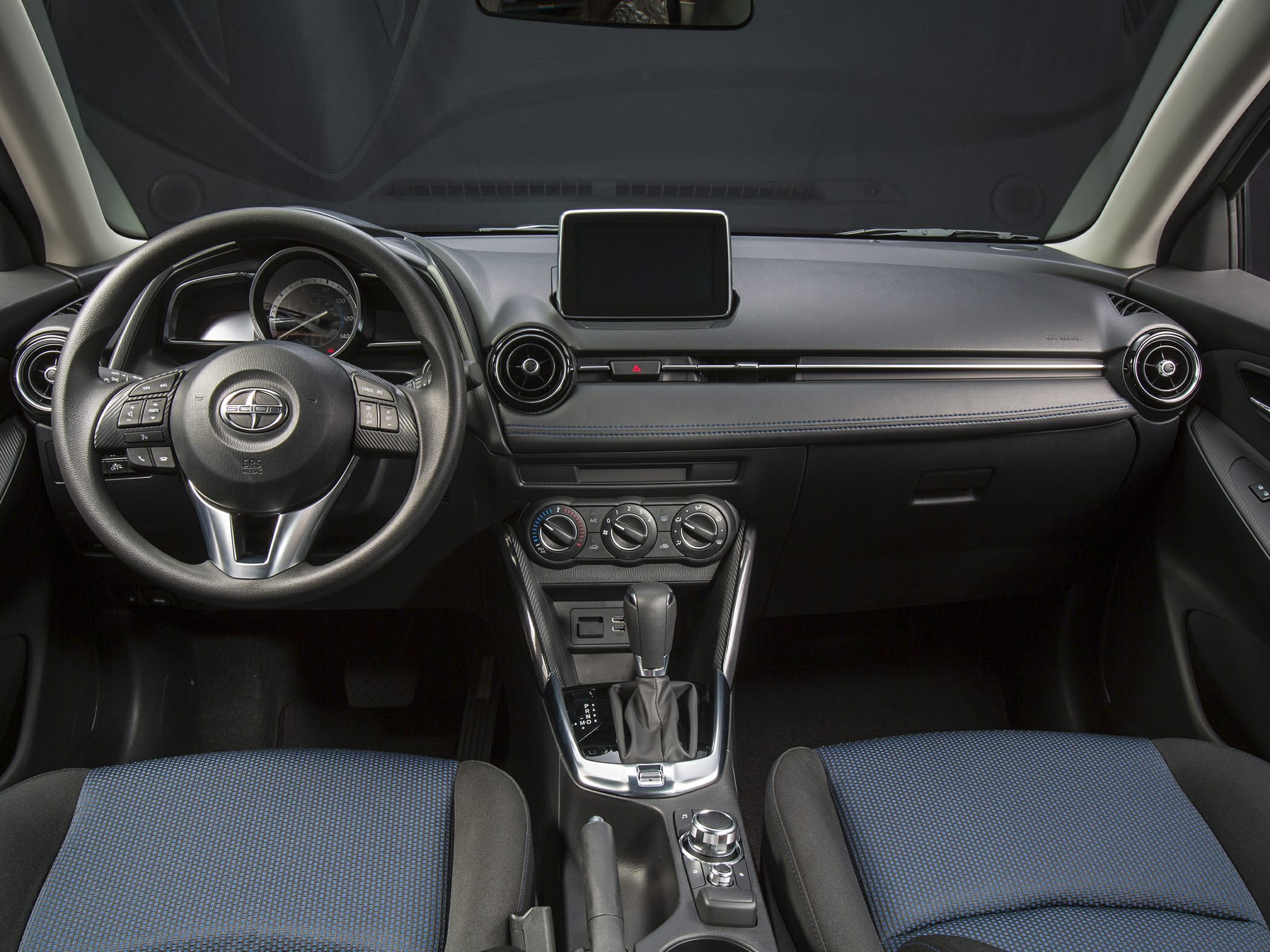Interior dashboard with steering wheel, air vents, digital display, and center console controls